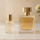 Two elegant perfume bottles with gold caps on a neutral vanity background