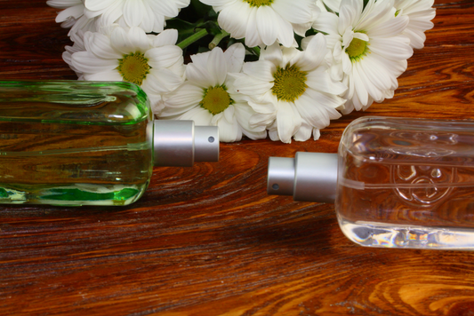 Perfume bottles with daisies, representing floral middle notes in fragrance composition.