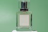 A sleek bottle of cologne with a green background showing how the scent can last longer and remain fresh for longer period of time