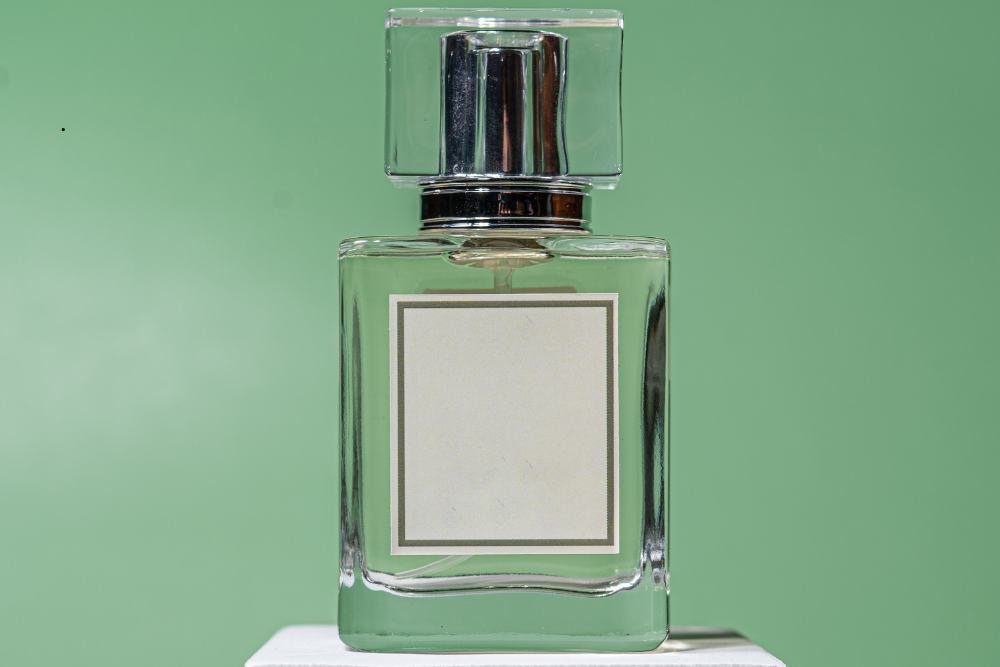 A sleek bottle of cologne with a green background showing how the scent can last longer and remain fresh for longer period of time