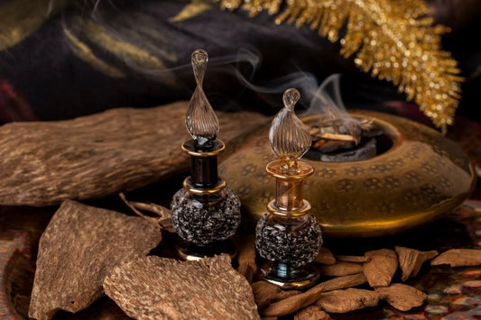 Oud oil bottles with agarwood chips and incense, showing what oud is in perfumes
