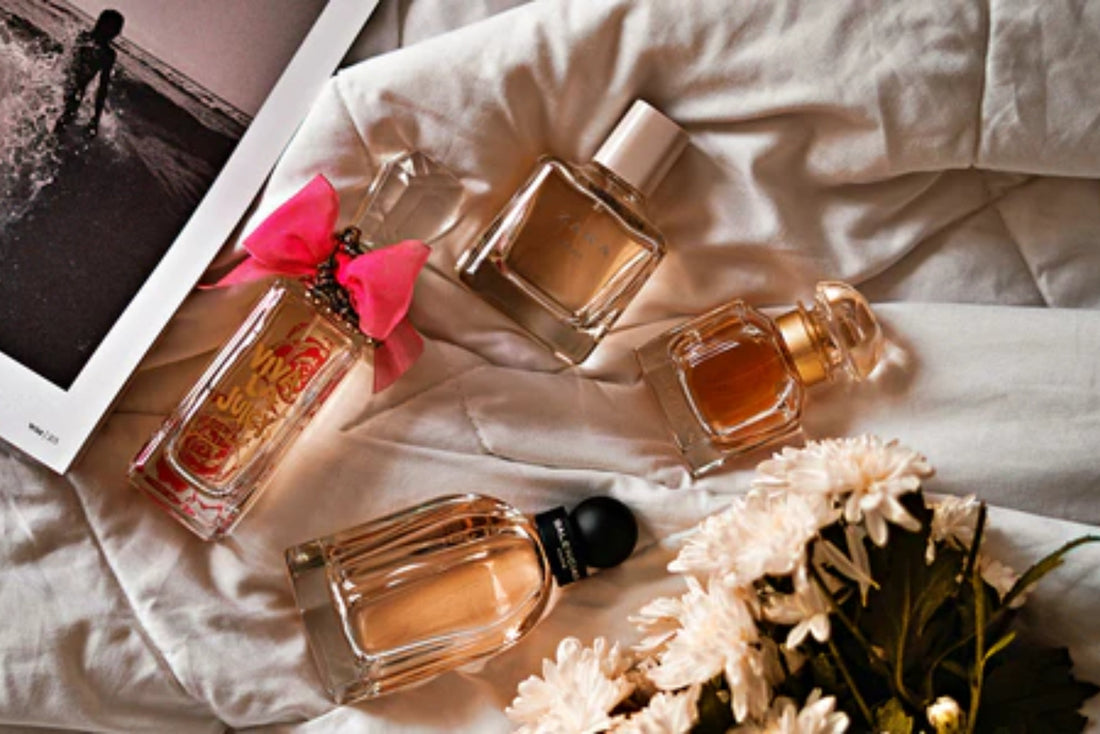 A variety of perfume sprays, including eau de parfum, eau de toilette, and body spray, displayed on a vanity.