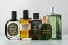 A lineup of various men's cologne bottles, including brands like Diptyque, D.S. & Durga, Chanel, Arquiste, and Hermès.