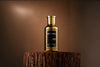 Bharara King Gold Edition Eau de Parfum bottle on a wooden pedestal.