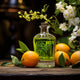 Green perfume bottle surrounded by oranges, glossy leaves, and white flowers on a wooden surface with a dark blurred background